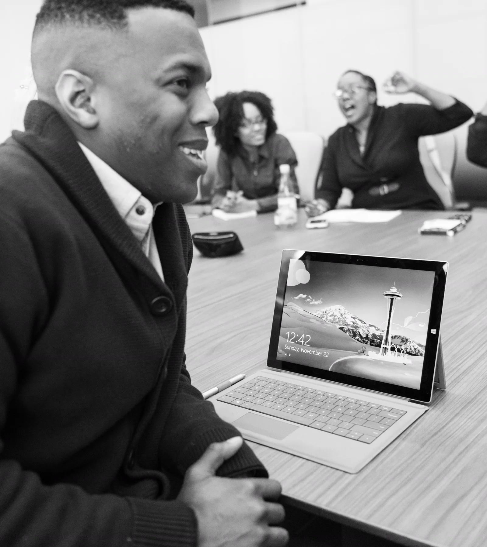 A suited technology professional in a formal meeting with colleagues
